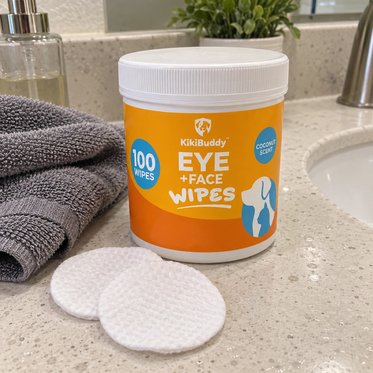 Orange pet wipe tub and round pads on a bathroom counter